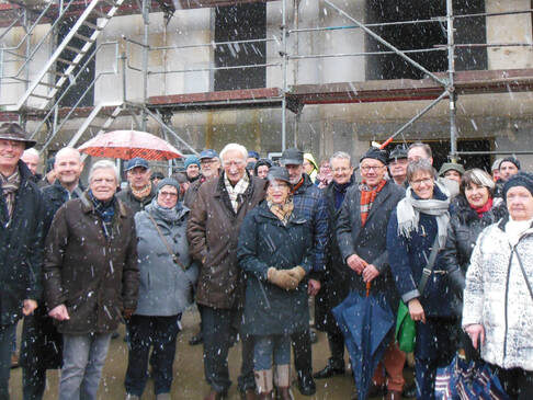 Viele Personen vor einem Haus welches gerade gebaut wird.