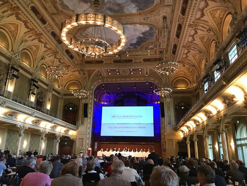 Die Historische STadthalle Wuppertal mit vielen Menschen von innen.
