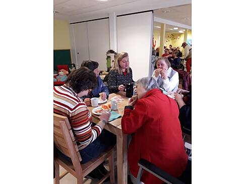 Mehrere Personen sitzen an einem Tisch und Essen.