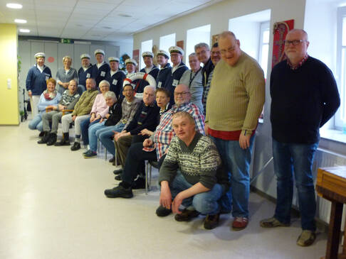 Gruppenfoto mit Sängern und Zuschauern.