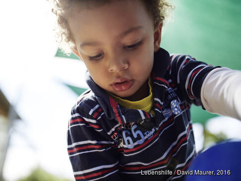 Ein Junge schaut auf etwas unter sich.