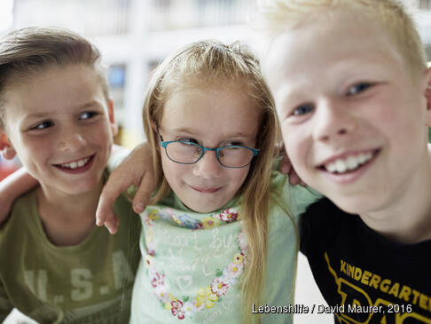 Drei Kinde rschauen und lachen.