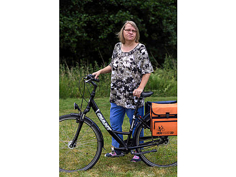 Eine Frau neben einem Fahrrad.