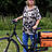 Eine Frau neben einem Fahrrad.