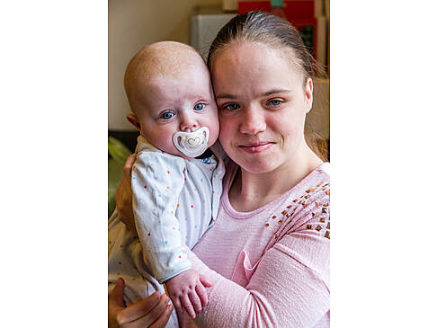 Eine Frau hält ein Baby auf dem Arm.