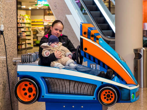 Eine Frau mit Baby sitzt im Fahrgeschäft.