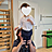 Bild zeigt eine Fachkraft, sie hält ein kleines Kind im Therapieraum hoch.