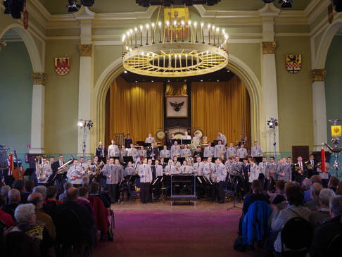 Ein Orchester steht vor Puplikum.