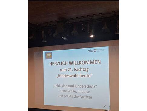 Ein Bild mit Herzlich Willkommen wird an die Wand projeziert.