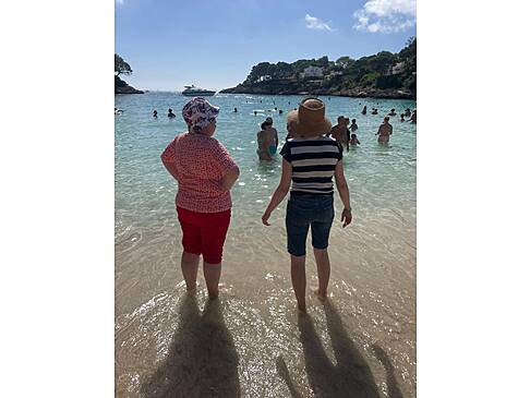 Zwei Gäste stehen mit den Füssen im Wasser.