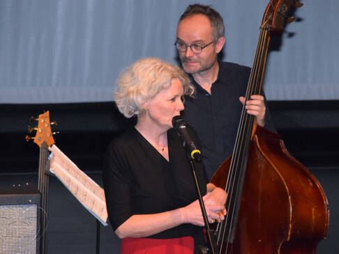 Ein Mann mit einem Kontrabass, eine Frau am Mirkofon.