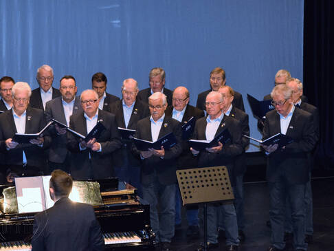 Ein Chor und ein Mann am Klavier.