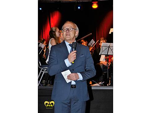 Dr, Schröder mit Mirkofon und Zetteln in der Hand.