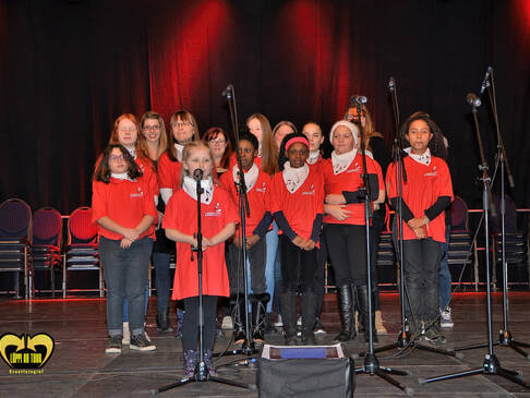 Ein Chor in roten TShirts singt.