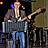 Ein Mann spielt Bass und schaut auf Noten.