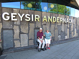 Zwei Menschen stehen vor einer Wand mit der Aufschrift „GEYSIR ANDERNACH“