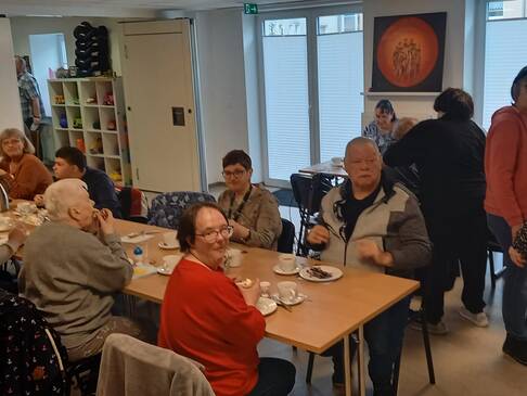 Bild drei zeigt Menschen beim Frühstück